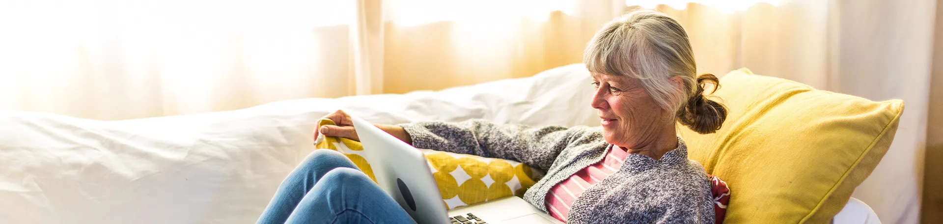 Older woman relaxing at home with a tablet